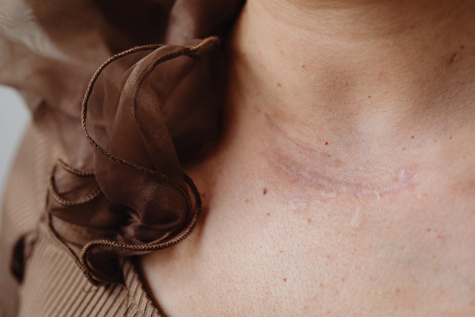 Close-up image of a neck scar with surrounding delicate brown fabric, highlighting skin texture and detail.